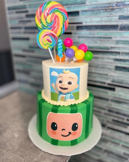 Cocomelon and lollipops, a custom cake made by Aya's Sweets